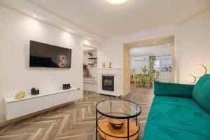 a living room with a green couch and a fireplace at Apartman Toni in Krk