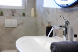 a bathroom with a sink and a faucet at Apartman Toni in Krk +21 photos