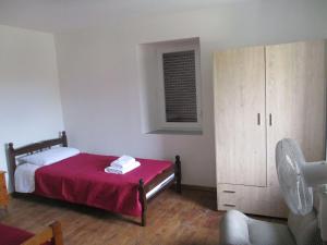 ein Schlafzimmer mit einem Bett mit einer roten Decke in der Unterkunft Karpasi House in Karpásion