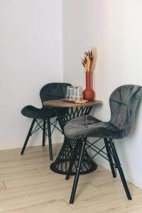 a table with two chairs and a vase on it at Villa Twins Techirghiol in Techirghiol