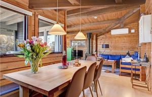 a dining room with a wooden table and chairs at Holiday Home Tværvangen in Ebeltoft