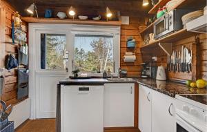 a kitchen with white cabinets and a window at Holiday Home Tværvangen in Ebeltoft