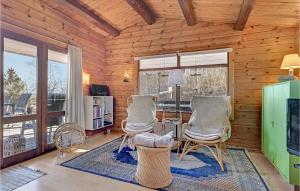 a living room with two chairs and a table at Holiday Home Tværvangen in Ebeltoft