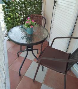 een tafel en stoelen op een patio met bloemen erop bij Vicky's Guesthouse in Kavos
