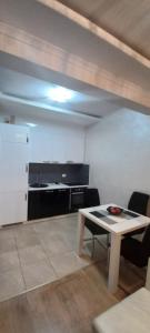 a living room with a table and a kitchen at LoreHan apartman 2 in Becici