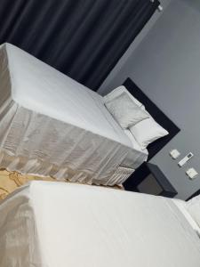 - un lit avec des draps et des oreillers blancs dans l'établissement Villa Fátima Hostel GRU, à Guarulhos
