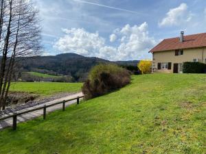 een huis in een veld naast een weg bij Aux Trois Gîtes in La Chapelle