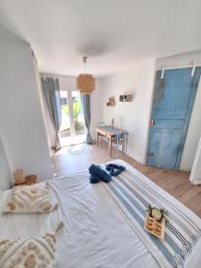 1 dormitorio con 1 cama blanca grande y puerta azul en Le spot Landais - Côté piscine, en Soustons