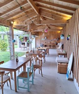 comedor con mesas y sillas de madera en Le spot Landais - Côté piscine, en Soustons