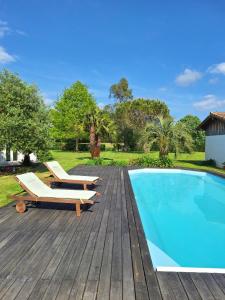 una terraza de madera con sillas y una piscina en Le spot Landais - Côté piscine, en Soustons