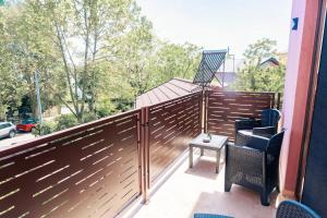 a wooden privacy fence on a balcony with a chair at Villa Twins Techirghiol in Techirghiol