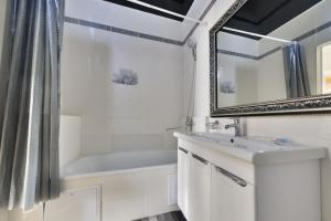 een badkamer met een bad, een wastafel en een spiegel bij Однокомнатные апартаменты на Мангилик ел 51 in Astana +4 foto's