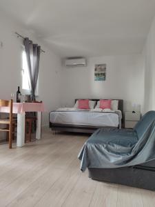 a bedroom with two beds and a desk and a table at Apartments Glibić in Zaostrog