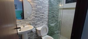 ein Badezimmer mit einem Waschbecken, einem WC und einem Spiegel in der Unterkunft Amaca Suites in Santa Cruz de la Sierra