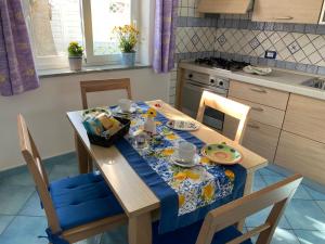 uma mesa de cozinha com uma toalha de mesa azul em Villa Adelina!!! La tua vacanza a 300 mt dal mare! em Ischia