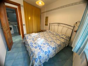 um quarto com uma cama com um edredão azul e branco em Villa Adelina!!! La tua vacanza a 300 mt dal mare! em Ischia