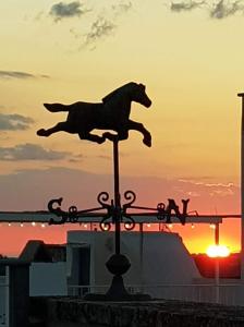 a statue of a horse jumping on top of a pole at La Corte delle Arti in Matino