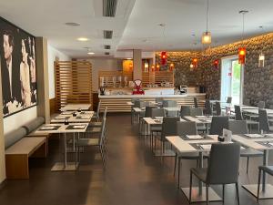 a dining room with tables and chairs in a restaurant at Hotel Cleofe in Caorle