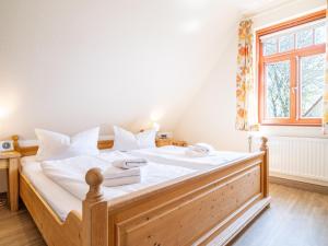 um quarto com uma cama com lençóis brancos e uma janela em Ferienhaussiedlung Strandperlen Buchenhof 3b (Typ III) em Wustrow