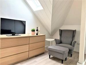 a living room with a tv and a chair at Uni-Klinikum- zentrale Lage von Holsterhausen in Essen