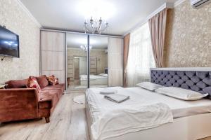 sypialnia z dużym łóżkiem i kanapą w obiekcie Однокомнатные апартаменты на Мангилик ел 51 w mieście Astana