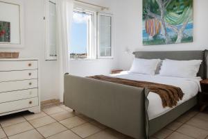 1 dormitorio con 1 cama, vestidor y ventana en Baos Pool Villas, en Mykonos ciudad