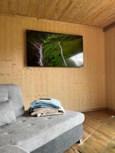 a living room with a couch and a tv on a wall at Zwiesler Haus Bschlabs in Bschlabs