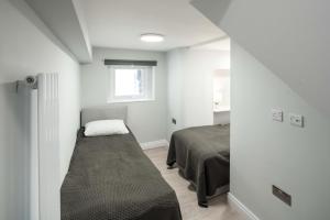 a small bedroom with a bed and a window at Tranquil Trio Bedrooms in London
