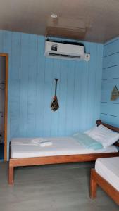 um quarto com uma cama com uma parede azul em Amazon Boto Lodge Hotel em Careiro