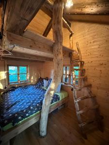 1 dormitorio con 1 cama en una cabaña de madera en Treehouse Family en Ořešín