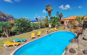 TanqueにあるFinca Del Cancelの家の隣にある黄色い椅子と椅子のあるプール
