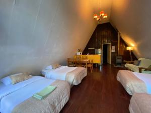 Habitación con 3 camas y comedor. en Centro Turístico Anticura Parque Nacional Puyehue, 