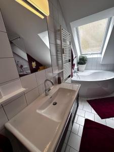 een witte badkamer met een wastafel en een bad bij TAMLiving Graz Center 2 Schlafzimmer Comfort Air conditioning WIFI XBOX in Graz +18 foto's