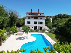 a house with a swimming pool in front of it at Green House Villa with Pool in Banjole
