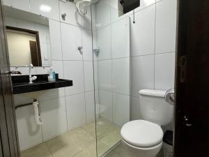 ein Bad mit einem WC und einer Glasdusche in der Unterkunft Acomodação aconchegante próximo ao centro in Garanhuns