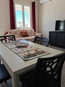 una mesa y sillas en una sala de estar con sofá en Sogno di Sicilia, en Marsala