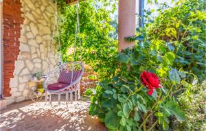 un'altalena in un giardino con una rosa rossa di 2 Bedroom Awesome Apartment In Medulin a Medulin