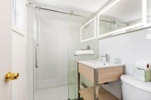 a bathroom with a shower and a sink and a toilet at Tropicana Motel Wildwood Beach & Boardwalk in Wildwood