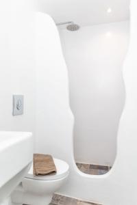 bagno bianco con servizi igienici e specchio di Luxury Naxos Suites Superior Quadruple Apartment City Center Modern Furnishing With Private Balcony Saint George a Naxos Chora