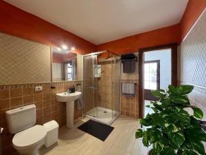 a bathroom with a toilet and a sink and a shower at Casa Valeria in Tinajo +35 photos
