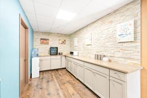 a kitchen with white cabinets and a brick wall at Tropicana Motel Wildwood Beach & Boardwalk in Wildwood
