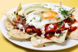 a plate of food with an egg on top of chips at Hotel Singular Antara in Mexico City