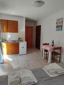 a kitchen and dining room with a table and a pink table at Apartments Glibić in Zaostrog