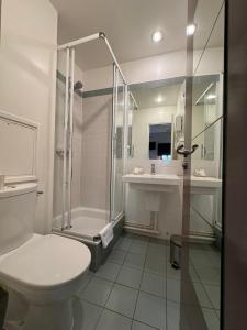 een badkamer met een toilet, een douche en een wastafel bij Hôtel Paris Vésinet in Le Vésinet