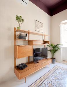 a wooden book shelf with a computer in a room at Birgu No 25 apartment 3 in Birgu