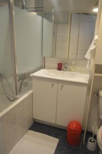 a white bathroom with a sink and a shower at Paris Ouest Appartment in Courbevoie