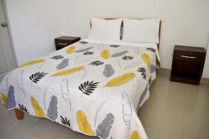 łóżko z kołdrą z liśćmi w obiekcie Hospedaje El Buen Samaritano w mieście Paracas