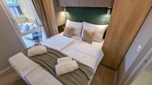 a bedroom with a white bed with a green headboard at Mobile Homes Jaki - 2 Bathrooms, Large Terrace in Biograd na Moru