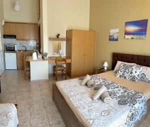 a bedroom with a large bed and a kitchen at Theodora’s Studios in Repanídhion +29 photos