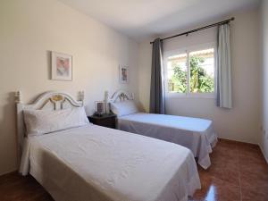 a bedroom with two beds and a window at Casa Nicole in Caleta De Fuste